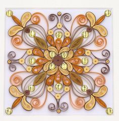 an intricately designed piece of paper with gold and brown designs on it, in the shape of a flower