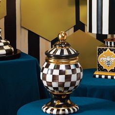 two black and white checkered vases sitting on top of a blue table cloth