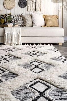 a living room with white walls and rugs on the floor