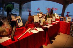 there are many pictures on the table with red cloths and flowers in vases