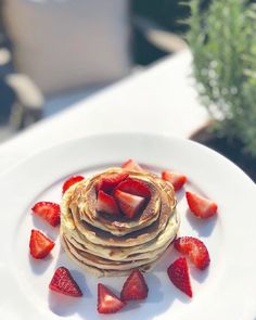 a stack of pancakes with strawberries on top