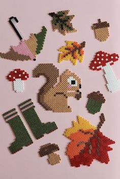 cross - stitch pattern with various items for needleing on pink background, including boots and mushrooms