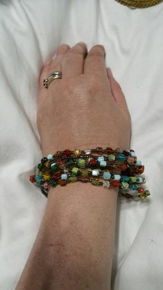 a woman is laying down with her arm wrapped around some bracelets on her wrist