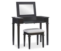 a small vanity with stool and mirror on it's side, in black finish