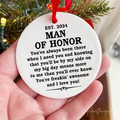 a person holding a christmas ornament with the words man of honor on it