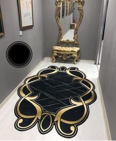 a black and gold rug in the middle of a hallway with an ornate mirror on the wall