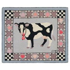 a black and white cow is standing in the middle of a patchwork rug with hearts on it