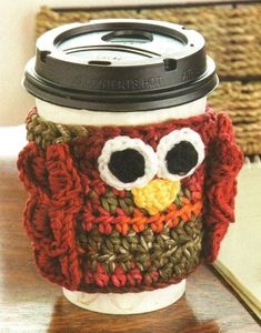 an owl coffee cup cozyie is sitting on a desk