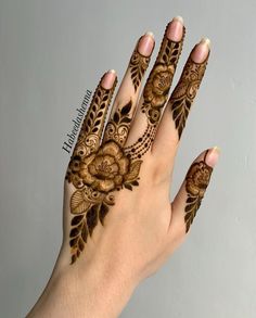 a woman's hand with henna tattoos on it