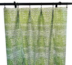 a green curtain hanging from a metal rod