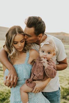 a man and woman holding a baby in their arms