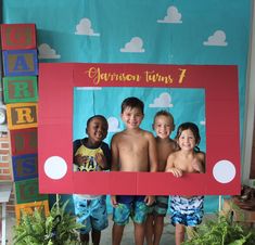 three children posing in front of a photo frame