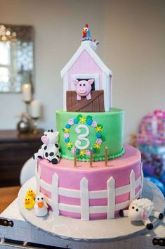 a three tiered cake decorated with farm animals