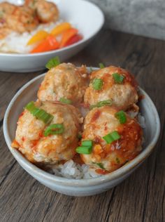 two bowls filled with meatballs and rice on top of a wooden table next to a bowl of vegetables