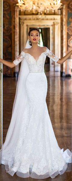 a woman in a white wedding dress is standing at an open door with her arms outstretched