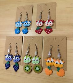 six pairs of earrings made to look like video games characters are shown in different colors and shapes