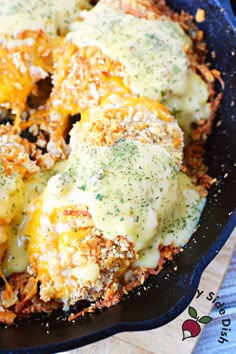 a skillet filled with cheese and meat covered in grated parmesan sauce