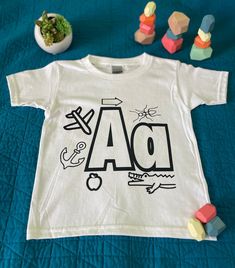 Coloring shirt for alphabet learning. A wonderful enrichment to play based learning. Hand created with a passion for young learners. Customized options, sizes and orders available.  Adult Supervision and Engagement is recommended. Single letter shirt only - additionally photographed items not included. Letter Shirt, Alphabet Learning, Single Letter, Play Based, Letter A Crafts, Play Based Learning, Custom Letters, Kids Tops, Lettering Alphabet