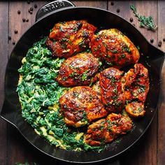 chicken and spinach in a skillet on a wooden table