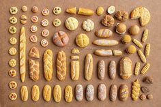 an assortment of breads and pastries laid out on a brown paper background,