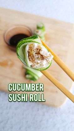 cucumber sushi roll on a chopping board with chopsticks and sauce