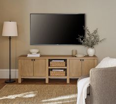 a flat screen tv mounted to the side of a wooden cabinet in a living room