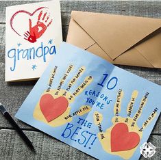 an envelope and some handprints are sitting on a table next to a card