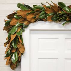 a wreath made out of leaves hangs on the front door