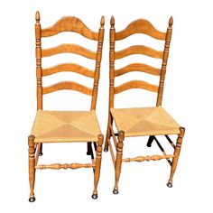 two wooden chairs sitting side by side against a white background