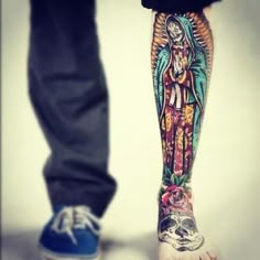 a person with tattoos on their legs standing next to another person's leg and foot