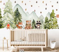 a baby's room decorated with woodland animals and trees