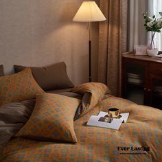 a hotel room with a bed, desk and lamp on it's headboard