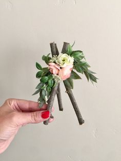 someone is holding some branches with flowers on them