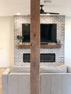 a living room with two couches and a flat screen tv mounted on the wall