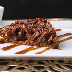 a piece of pecan pie on a white plate with caramel drizzle