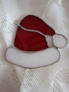 a red and white santa hat on top of a tablecloth covered cloth with scissors