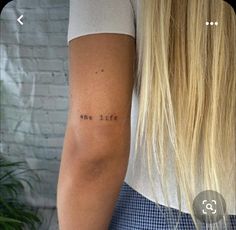 the back of a woman's arm with a tattoo saying one life on it