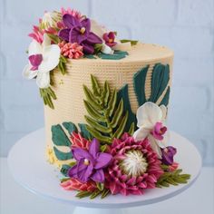 a cake decorated with flowers and leaves on a plate