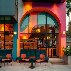 colorfully painted building with tables and chairs in front of the entrance to an eatery