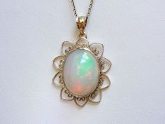 "This Mid Century, simple pendant is a great frame for the outstanding Ethiopian Opal gem that we've set at the center. This is a wonderful stone, filled not only with greens and oranges, but also with a rare, pink glow at the center! The radiant style of the frame certainly brings out the glow of the opal! This pendant does not come with the chain shown. Please feel free to contact us, we will help you find the perfect chain for your style and budget! Metal: 14K Yellow Gold Gem: Ethiopian Opal Simple Pendant, The Glow, Oval Cabochon, Eternity Bands, Ethiopian Opal, Green And Orange, Opal