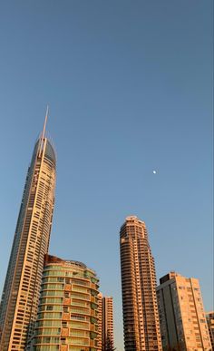 two tall buildings in front of a clear blue sky