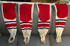 three pairs of red and white skis hanging from the back of a couch