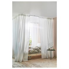 a bedroom with white curtains and a bed