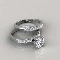 two white gold wedding rings with diamonds on each one and an engagement ring in the middle