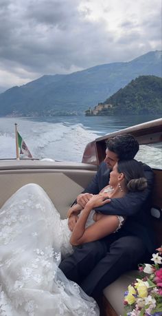 a bride and groom sitting on the back of a boat