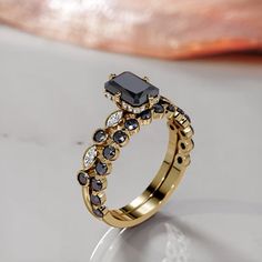 a black and white diamond ring sitting on top of a table