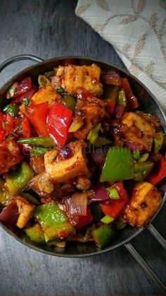 a pan filled with chicken and vegetables on top of a table