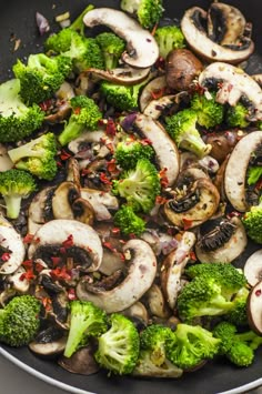 mushrooms and broccoli are cooking in a wok