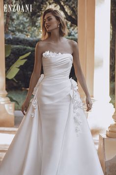 a woman in a white wedding dress is posing for the camera with her hand on her hip