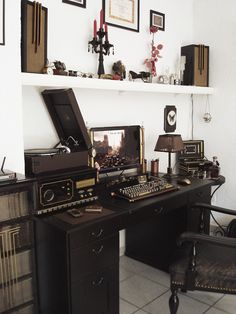 a desk with a computer and other items on top of it in a living room